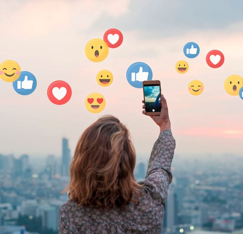 Taking a photo of a sunset with social media reaction icons