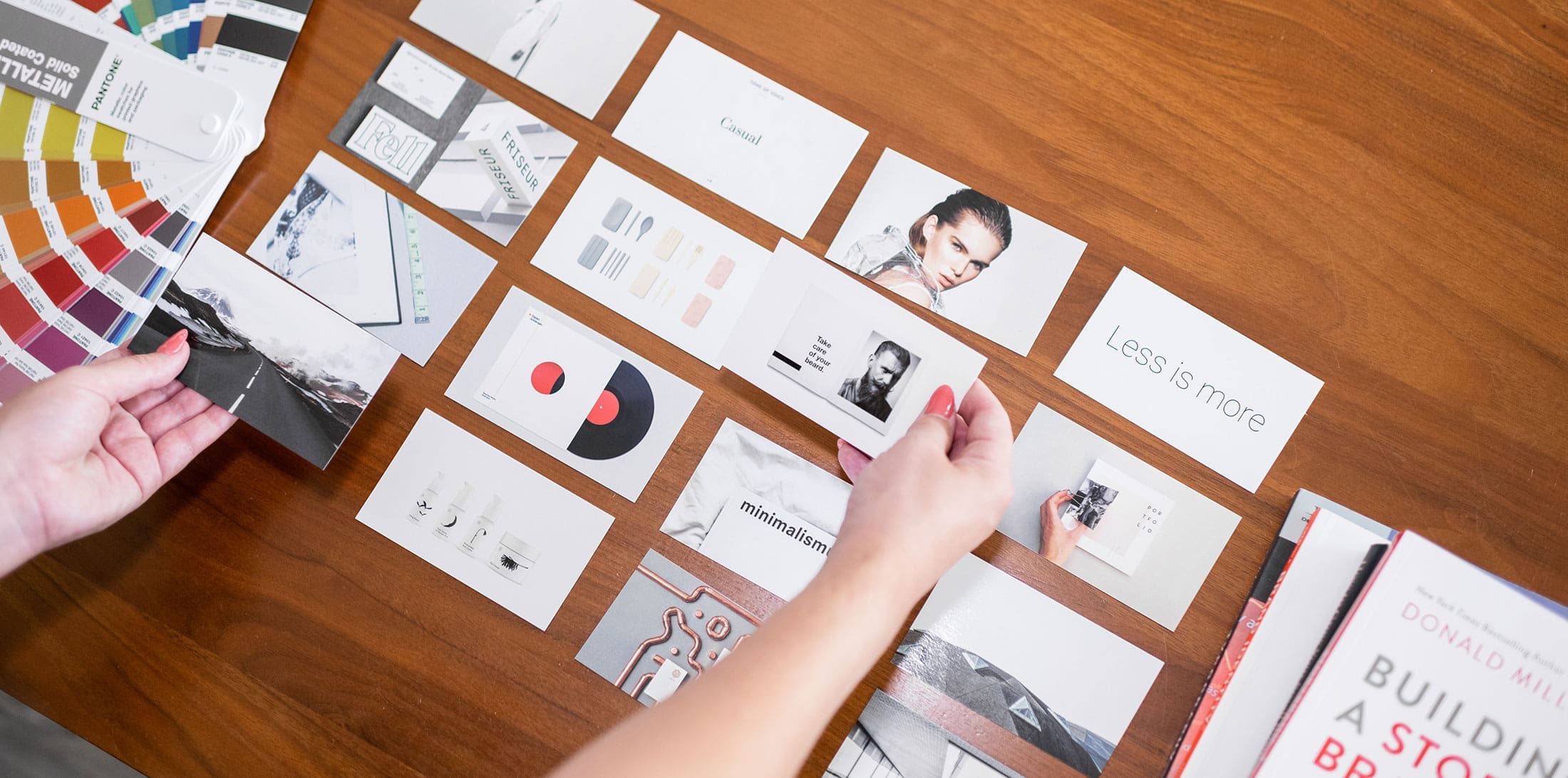 A lady is assembling a branding strategy with printed products on her desk to determine the Brand identity