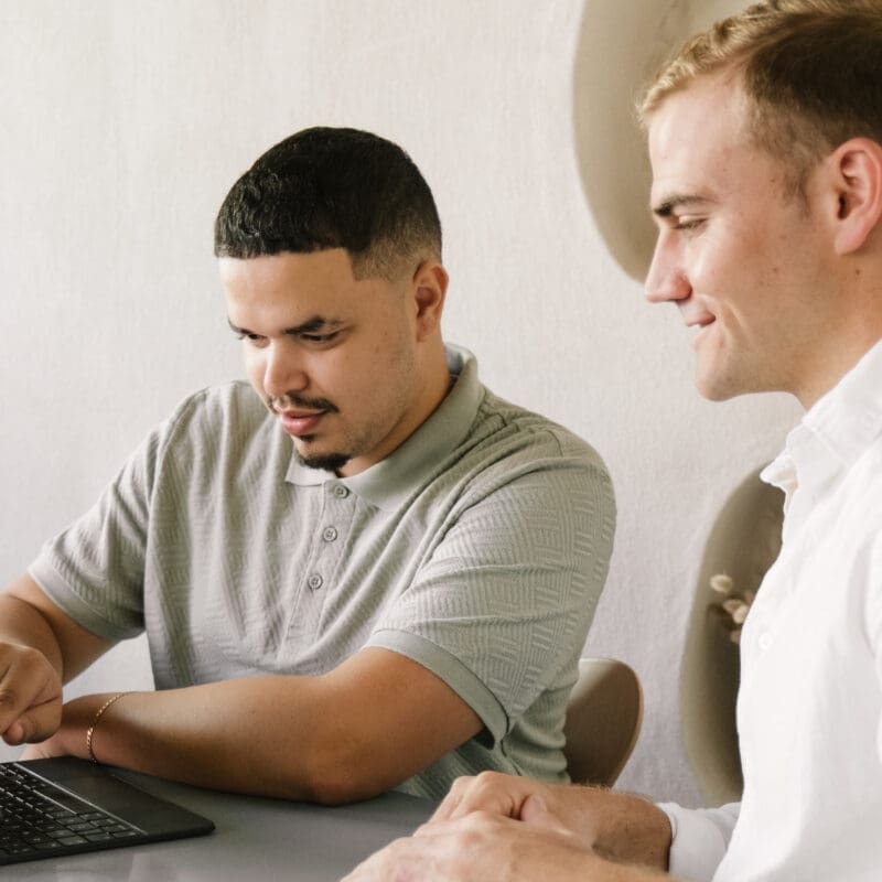 Two Don Creative Group team members reviewing work together on a tablet