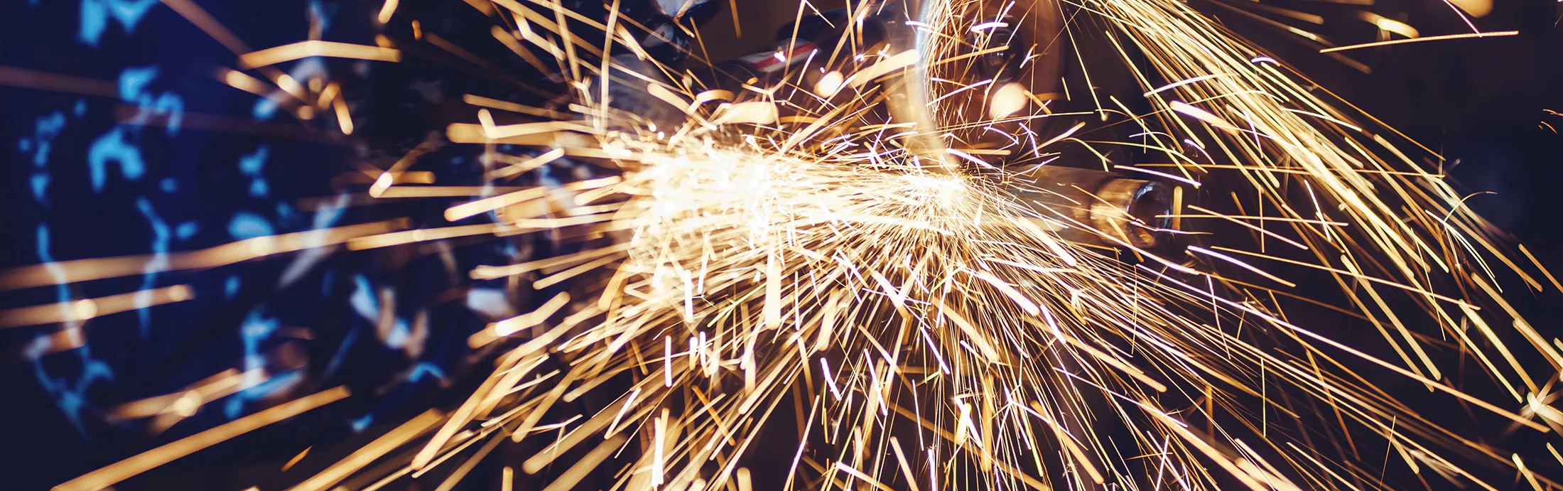 Metal cutting process creating sparks during industrial fabrication work