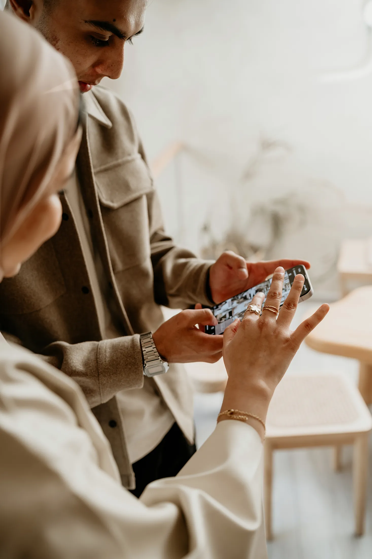 Two professionals reviewing visual content together on a smartphone during a collaborative discussion